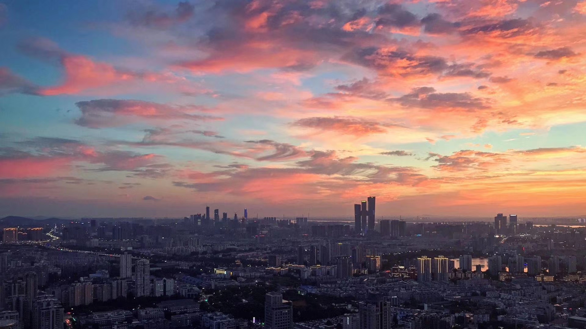 Aerial view of a city at sunset with pink clouds