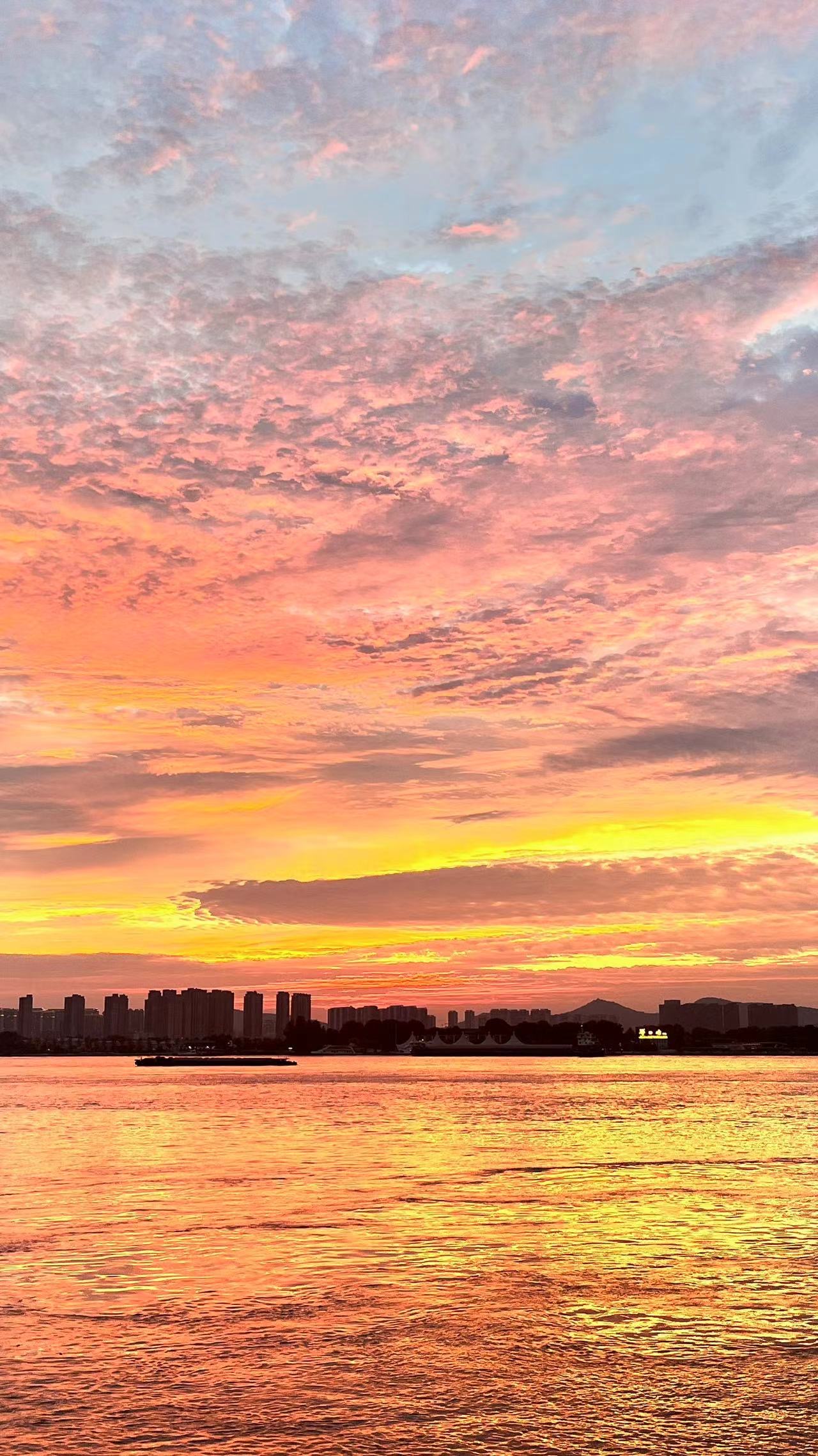 Golden sunset over a river with city skyline